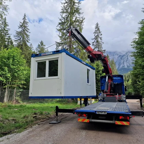 Container wird mit Kran vom LKW gehoben