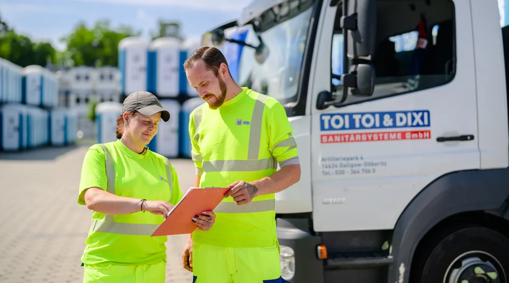 Personen mit einem Klemmbrett in Arbeitskleidung
