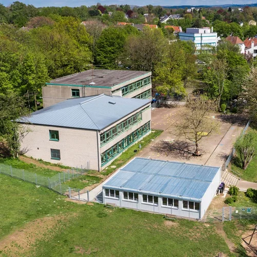 Luftbild von einem Gebäude, daneben eine Containeranlage